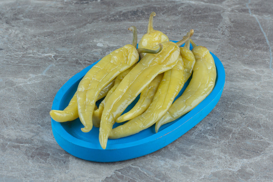 Green pickled pepper in blue plastic dish